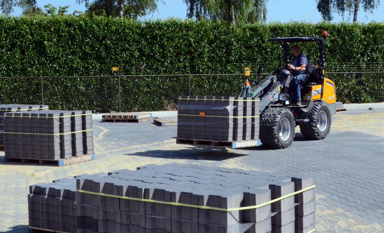 CHARGEUSE GIANT G2700 HD+ X-TRA transportant une palette de béton sur brique pour le revêtement de sol