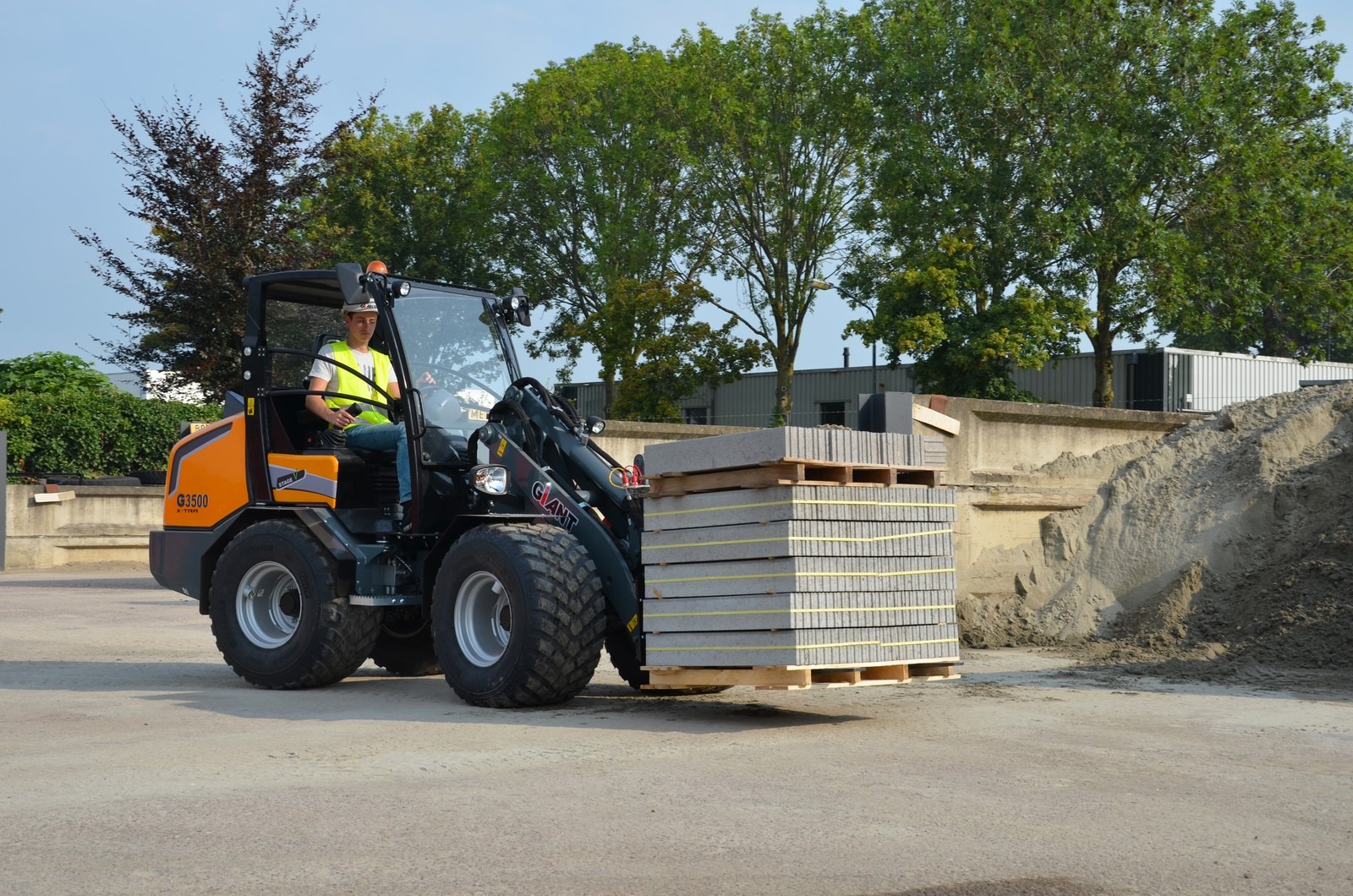 Transport de bordures en béton sur palette à l'aide de la CHARGEUSE GIANT G3500 X-TRA qui est à retrouver en location et en vente chez PrimBTP de toute la France